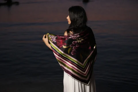 Evening Bloom worn over the shoulders, seen from behind by the sea